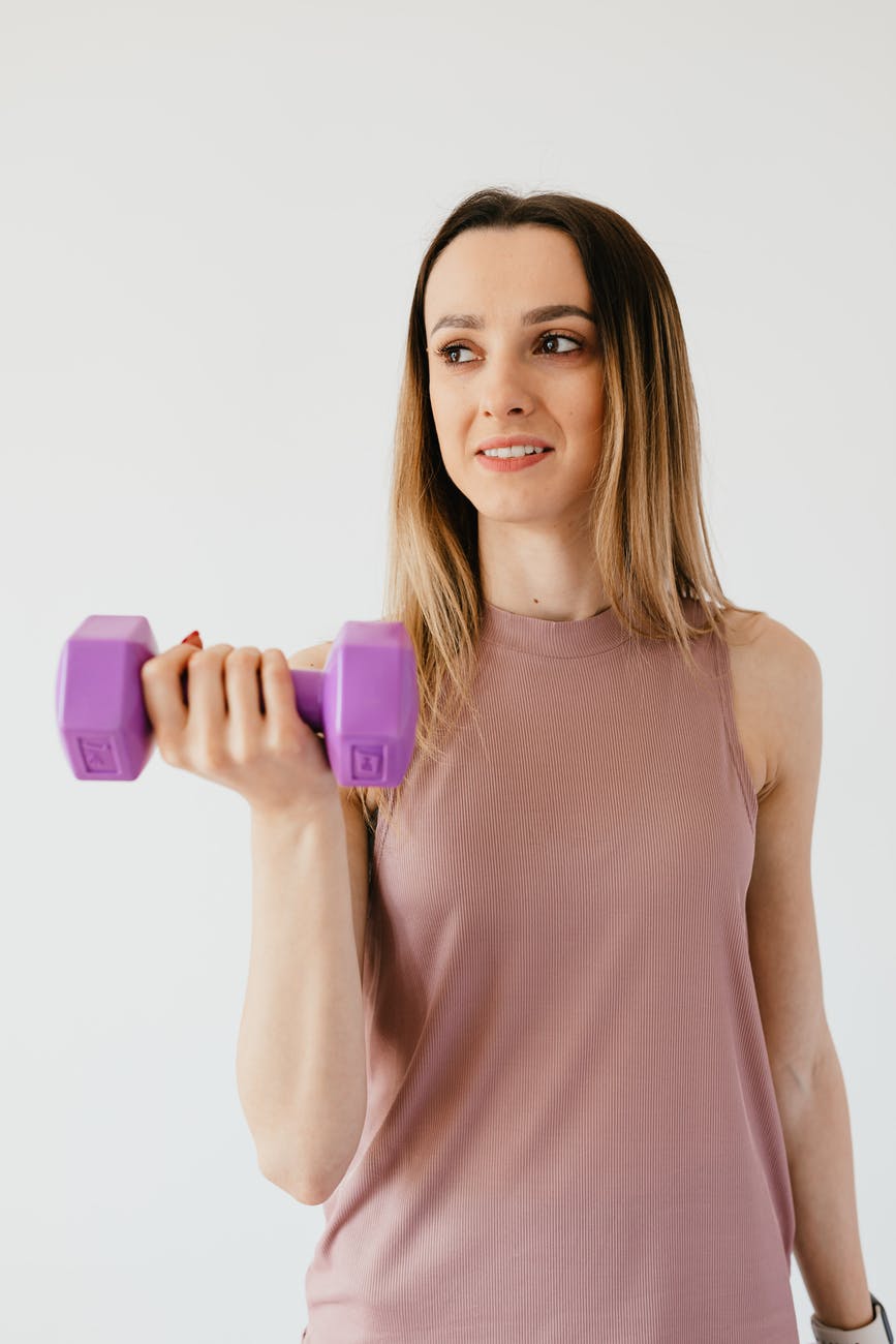 happy young sportswoman doing exercise with dumbbell