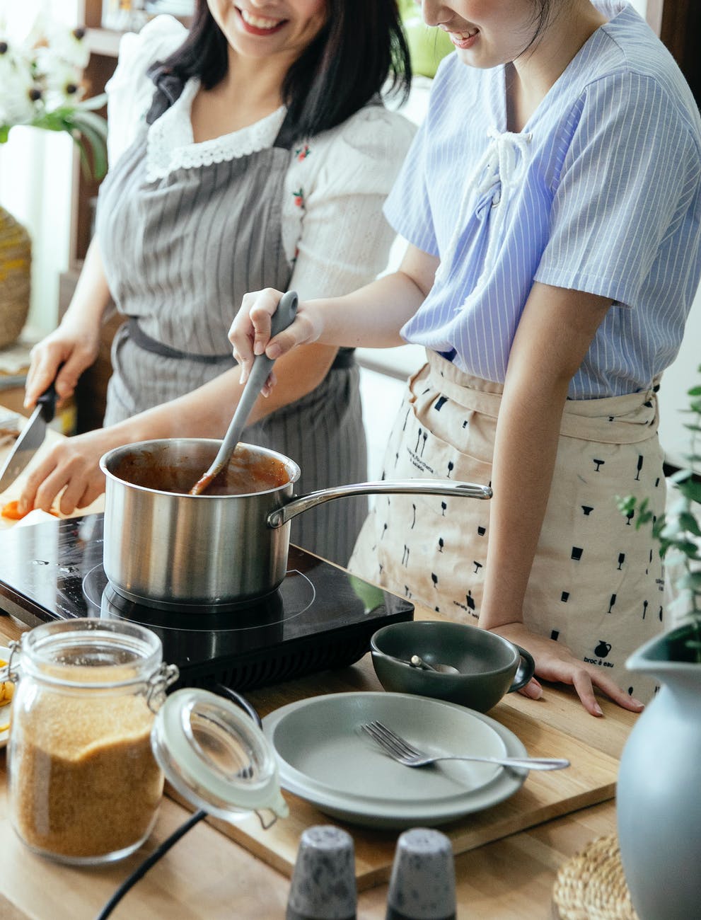 crop women cooking together in kitchen