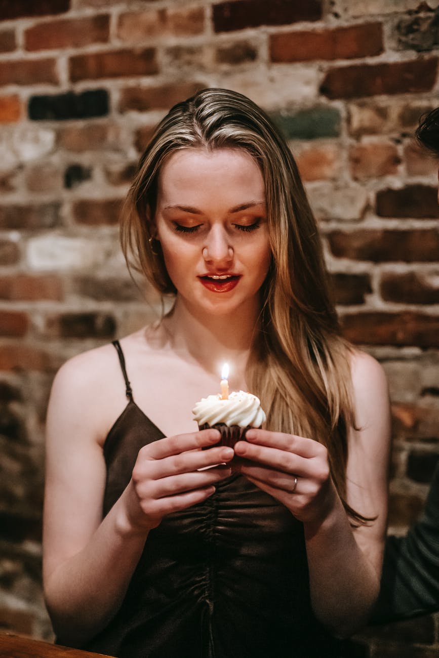 young woman with cupcake and candle
