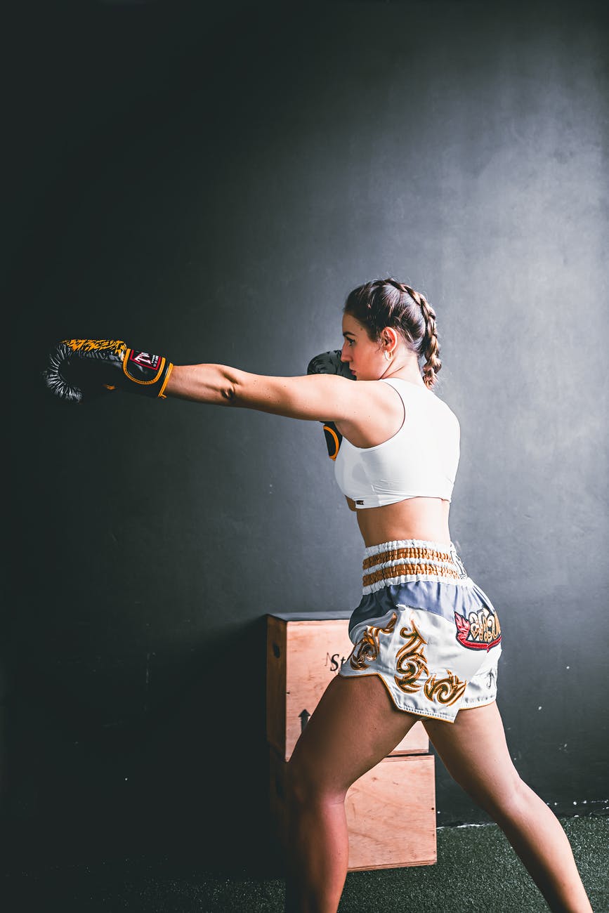 young strong woman in trendy sporty shorts boxing