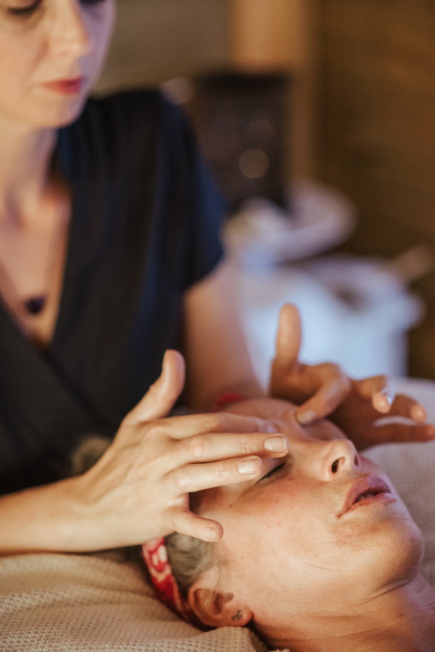 woman with closed eyes getting massage in salon