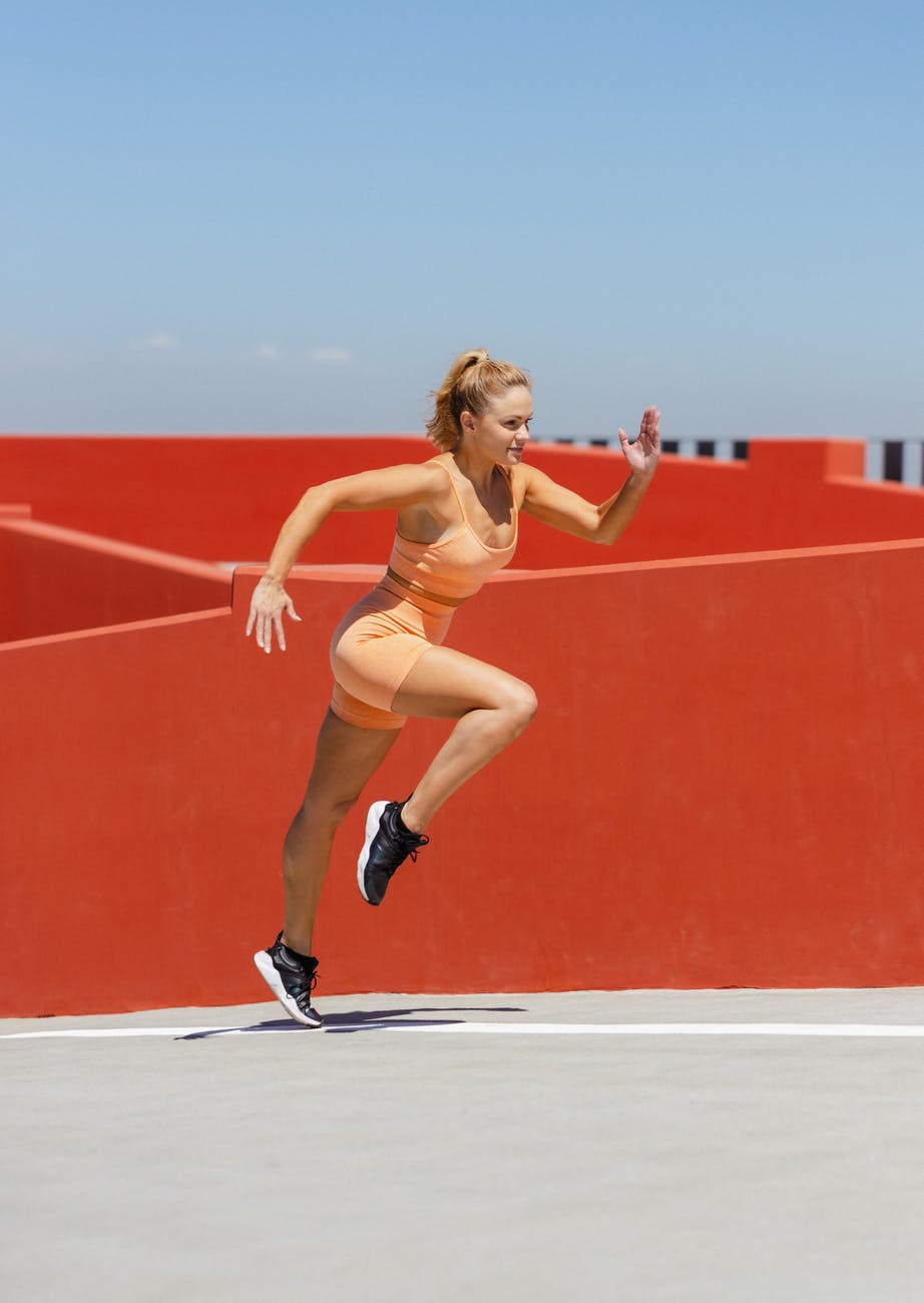 woman in orange sports wear running